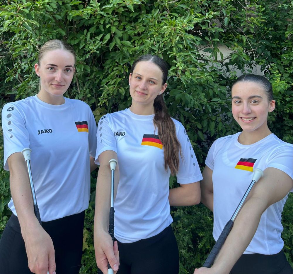 Drei Twirlerinnen im Nationaltrikot mit Stäben