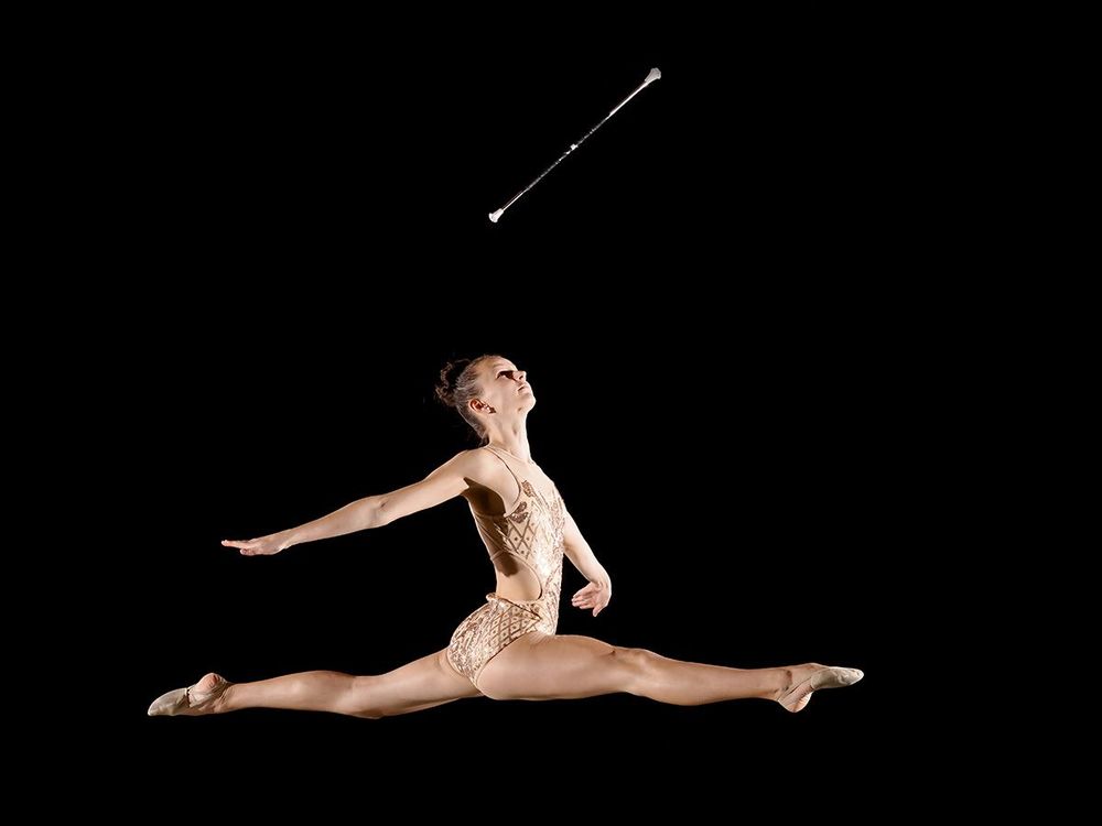 Twirlerin Lea im Spagatsprung mit fliegendem Stab