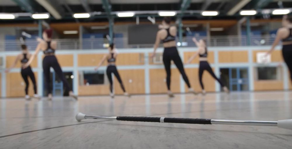 Twirlerinnen beim Training in der Halle, Stab am Boden