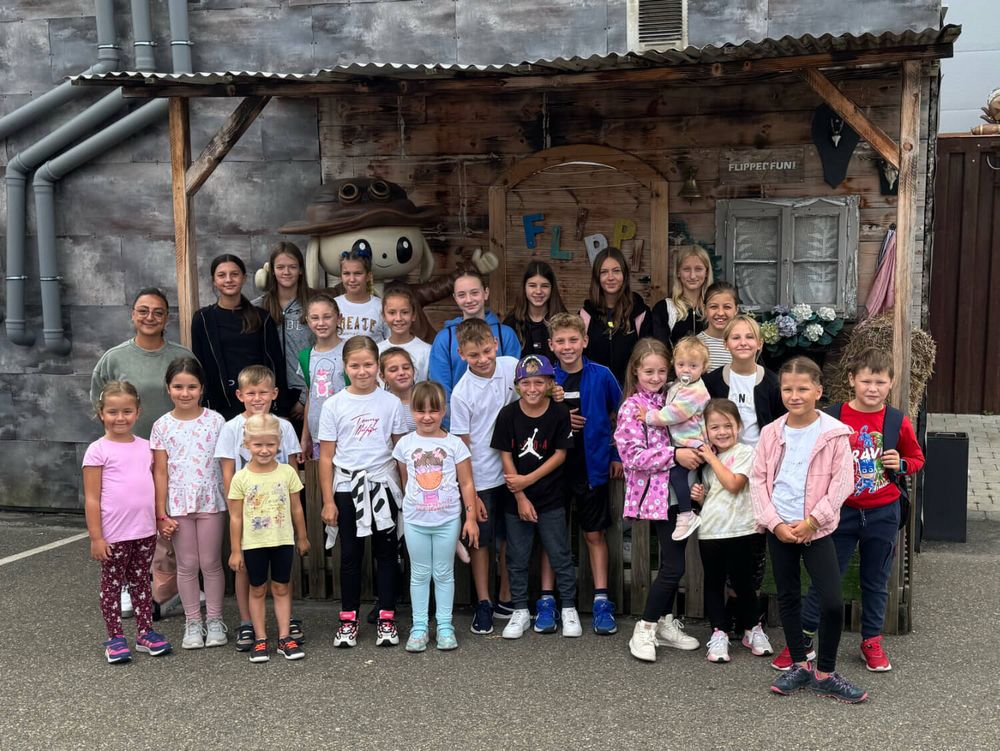 Kindergruppe beim Vereinsausflug vor Holzhaus