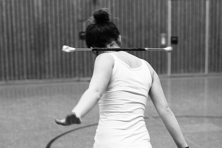Juniorin mit Stab im Nacken beim Training