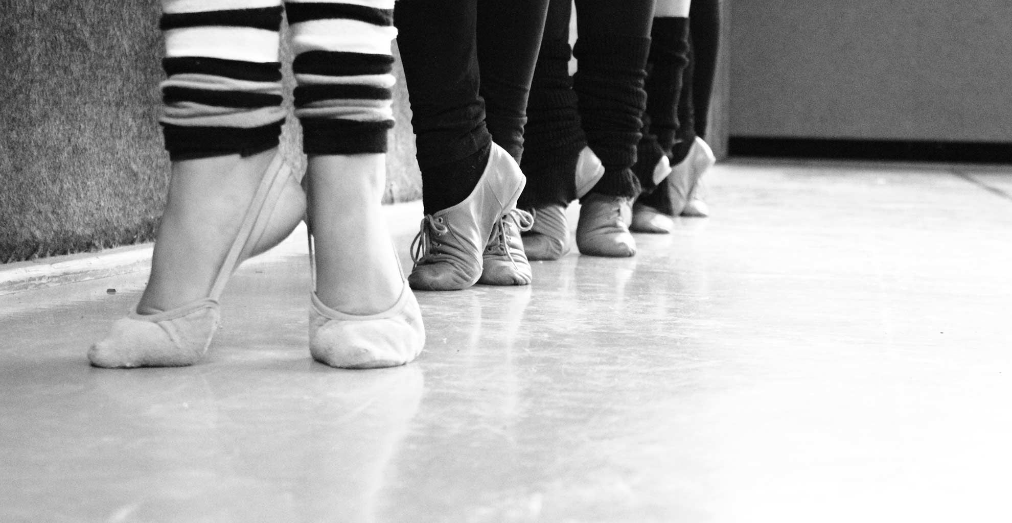 Füße von Tänzerinnen in Ballettschuhen mit Stulpen